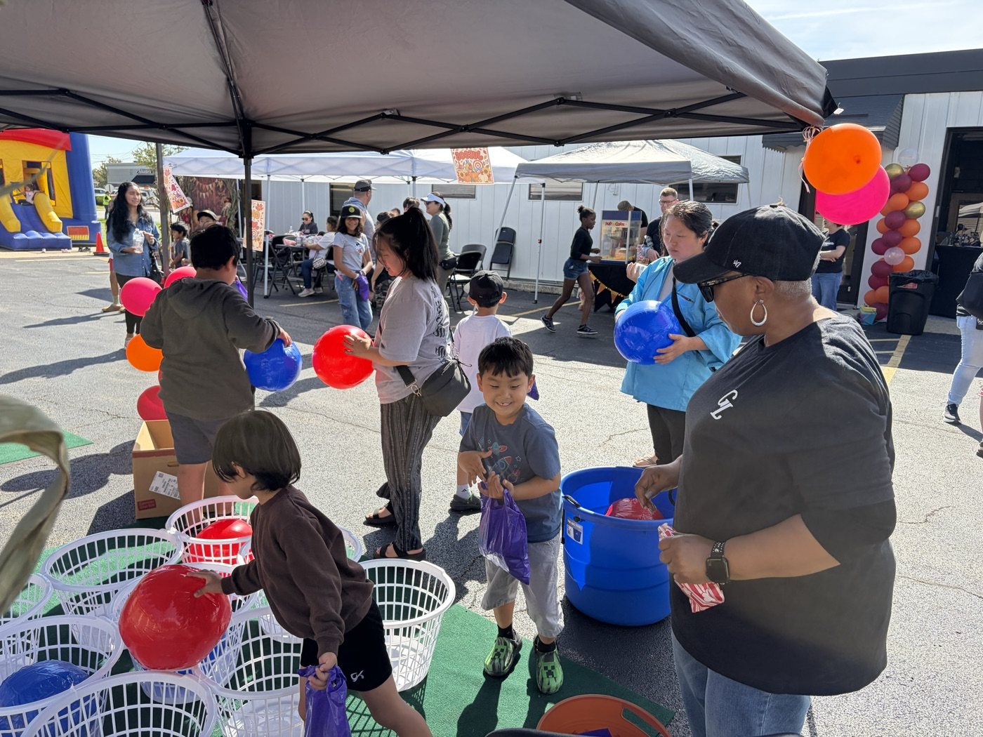 Familias y voluntarios comparten juegos con globos durante el evento comunitario de Gospelife.