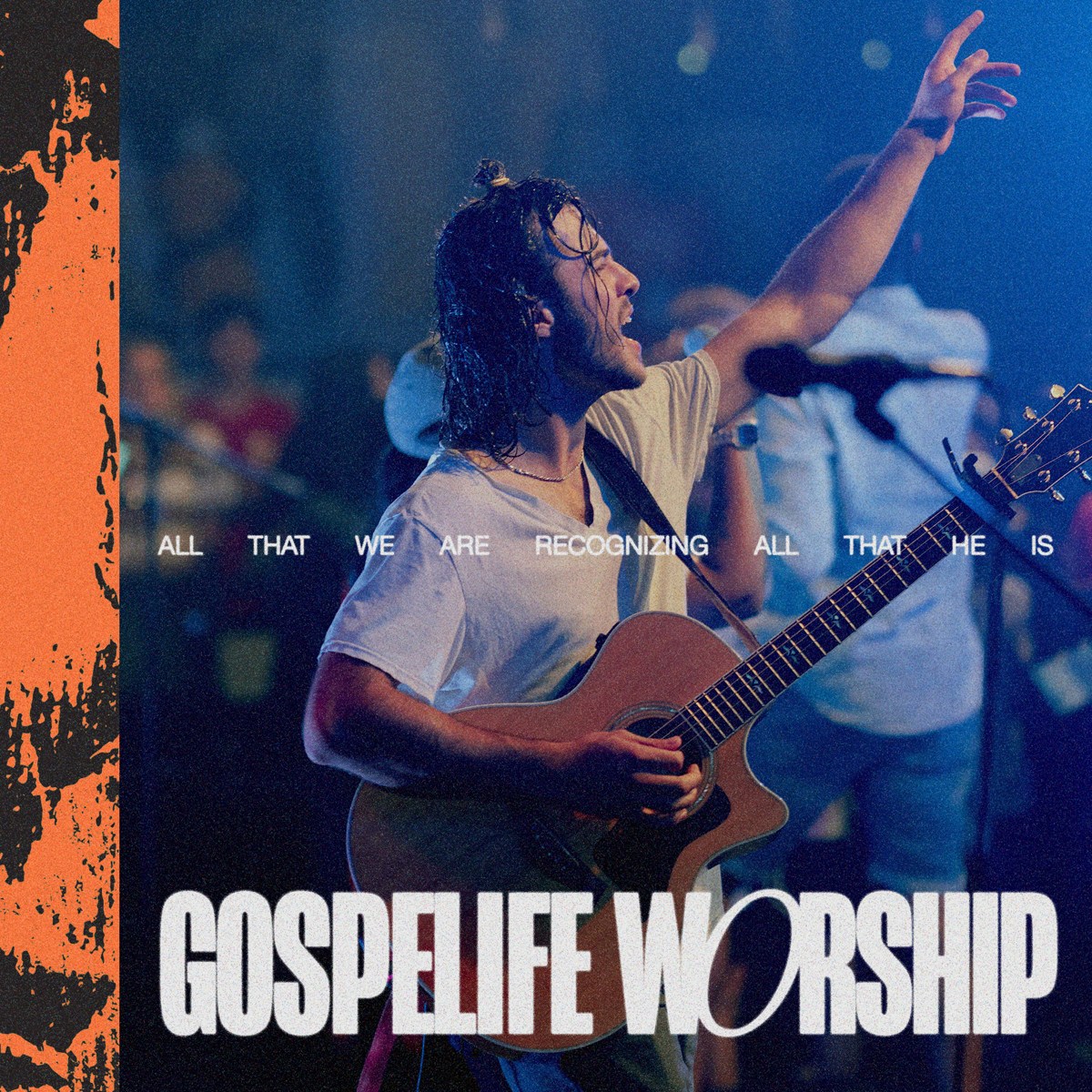 A Gospelife musician worshiping with a raised hand and guitar
