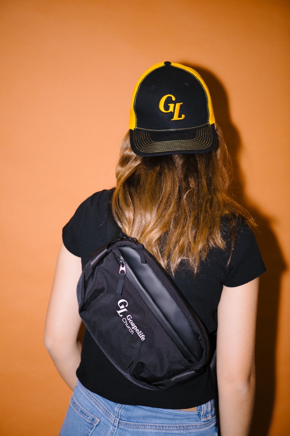 A Gospelife crossbody bag and black-and-gold cap