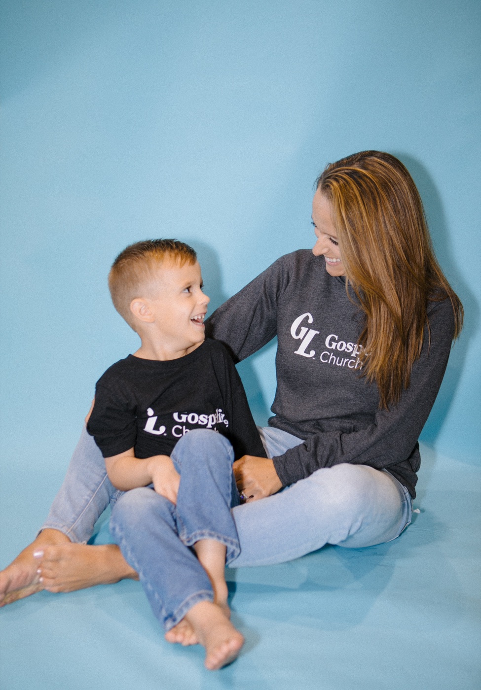 A woman and child wearing Gospelife sweatshirts and a T-shirt